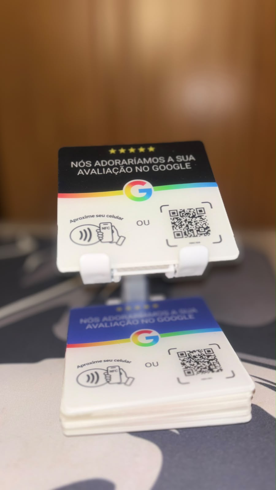 Plaquinha NFC preta no suporte e plaquinhas azuis empilhadas